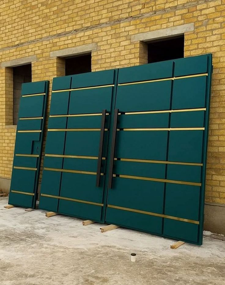 Fabricated teal and gold trimmed metal gate panels awaiting installation