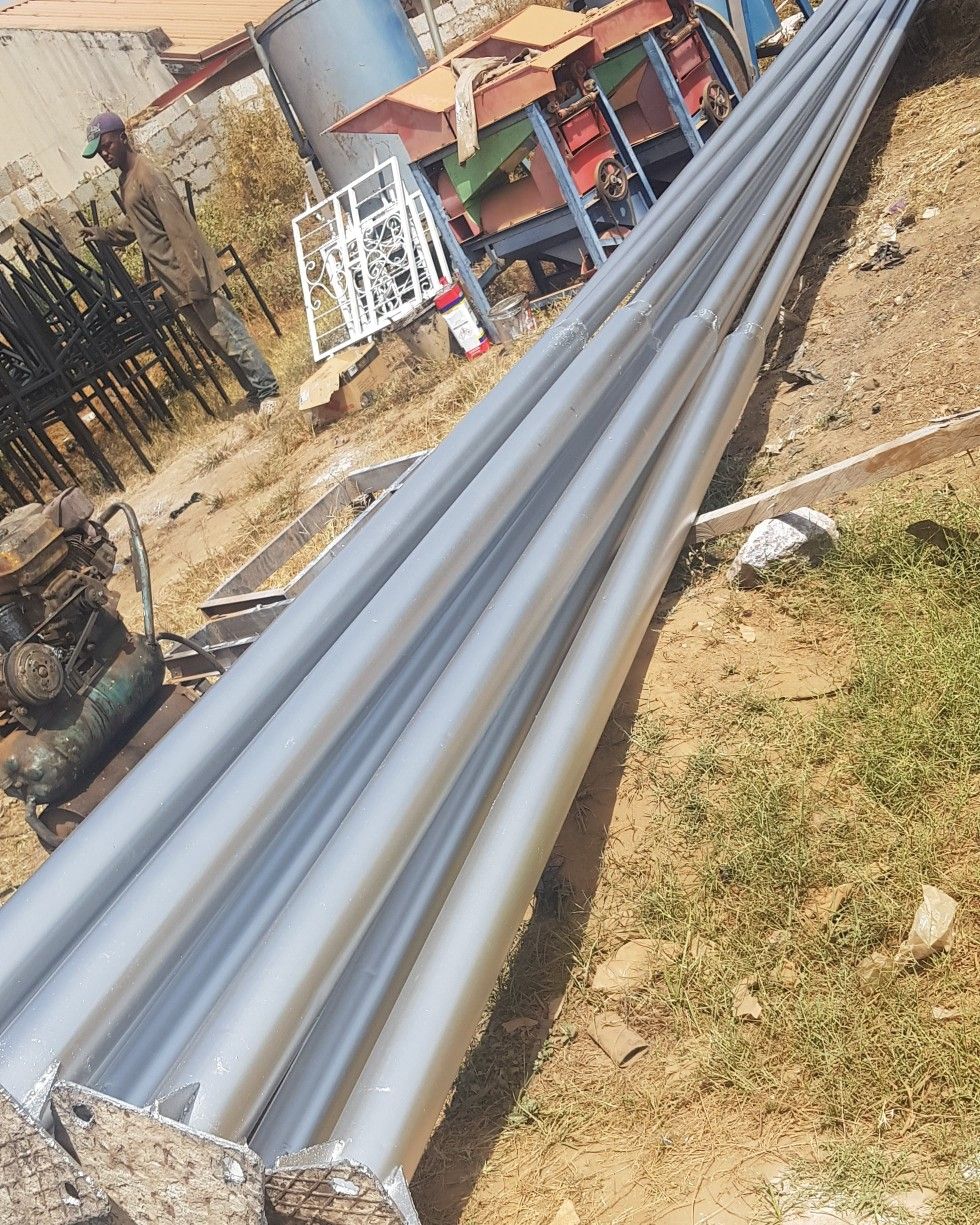 Galvanised street-light poles laid out on site ready for installation