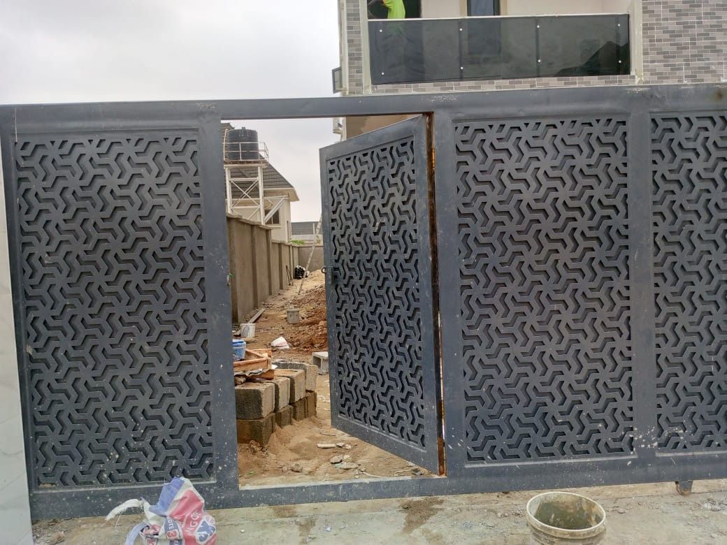 Grey sliding driveway gate with laser-cut flowing pattern panels