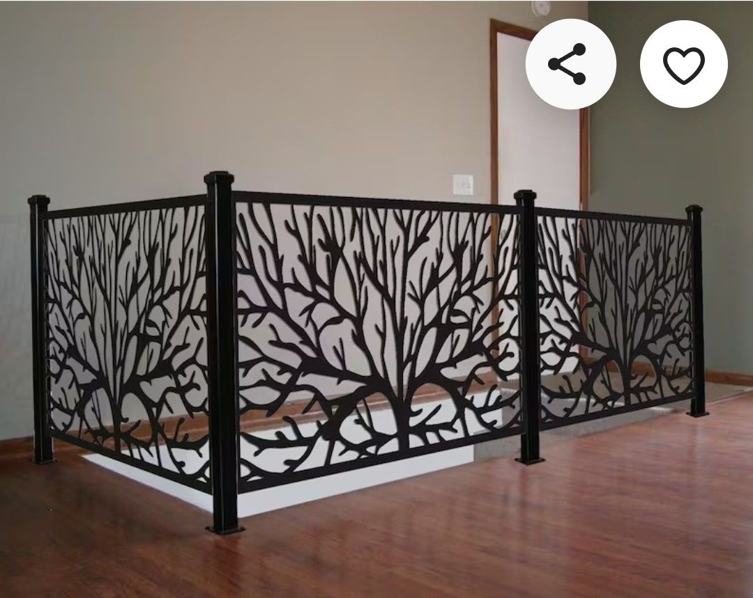 Black laser-cut tree-pattern metal railing panels with steel posts on an interior landing