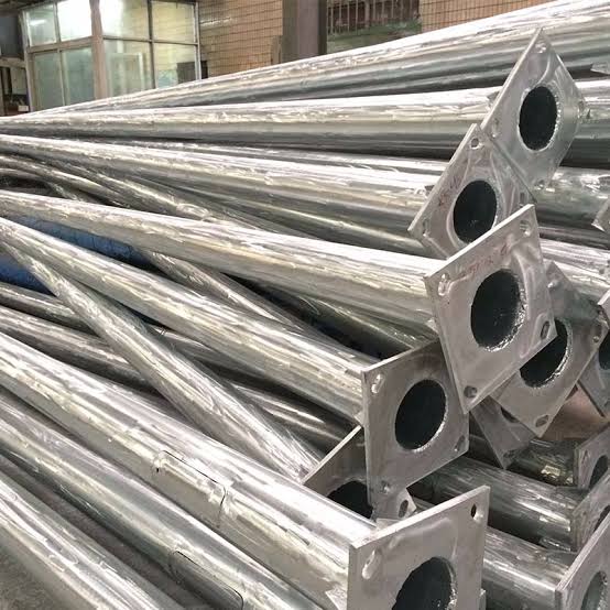 Stacked galvanised octagonal street-light poles with base plates